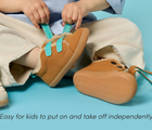 Child putting on Ten Little Cozy Suede Sneakers, easy for kids to put on and take off independently - Toffee Brown. Available at www.tenlittle.com