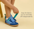 Child independently putting on Ten Little Retro Suede Sneakers - Retro Blue. Available at www.tenlittle.com