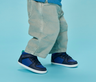 Side view child wearing Ten Little Varsity Mid Tops - Game Day Blue. Available at www.tenlittle.com