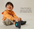 Child sitting wearing Ten Little Volt High Tops - easy for kids to put on and take off independently. Available at www.tenlittle.com
