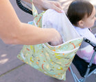 Woman utilizing the Bumkins Wet/Dry Bag - Camp Gear with baby in stroller. Available from www.tenlittle.com