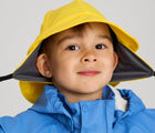 Close up of boy wearing Reima - Rain Hat - Yellow - Available at www.tenlittle.com