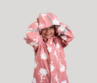 Child with hood on wearing Reima Waterproof Rain Jacket - Vesi - Rose Blush. Available at www.tenlittle.com