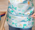 Close up of Bumkins Short-Sleeved Art Smock - Dinosaurs. Available from www.tenlittle.com