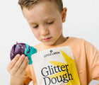 Child holding Little Larch Glitter Dough - Cosmic. Available from www.tenlittle.com
