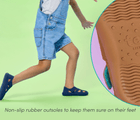 Split view of non-slip rubber outsole to keep sure on foot and child wearing Ten Little Everyday Sandals - Slate Blue and Sandy Brown. Available at www.tenlittle.com