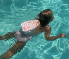 Girl swimming in pool wearing Sunnylife Bubble Back Float - Cherry. Available at www.tenlittle.com