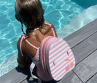 Girl sitting at pool wearing Sunnylife Bubble Back Float - Cherry. Available at www.tenlittle.com