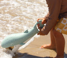 Child scooping sand with Sunnylife Sand Claw - Whale. Available at www.tenlittle.com