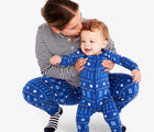 Mom holding baby wearing Primary - Baby 2-Pack Holiday PJs - Festive Lights - Available at www.tenlittle.com