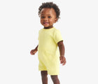 Baby wearing Primary Baby French Terry Romper - Buttercup. Available at www.tenlittle.com