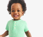 Child wearing Primary Baby Henley Romper - Clover. Available at www.tenlittle.com