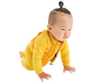Baby crawling wearing Primary Baby Lightweight Puffer Vest - Mustard. Available at www.tenlittle.com