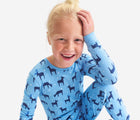 Child wearing Primary Holiday PJ Set - Snowy Reindeer - Cornflower Reindeer. Available at www.tenlittle.com