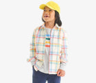 Child wearing Primary Long Sleeve Button Down - Rainbow Flannel - Marshmallow / Rainbow Plaid. Available at www.tenlittle.com