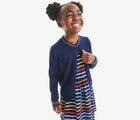 Child wearing Primary Long Sleeve Pocket Dress - Rainbow Stripe - Navy / Rainbow Stripe. Available at www.tenlittle.com
