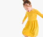Child wearing Primary Long Sleeve Pocket Dress - Sunflower. Available at www.tenlittle.com