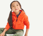Child wearing Primary French Terry Zip Hoodie - Orange. Available at www.tenlittle.com