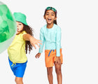 Kids wearing Primary Swim Trunks - 2 Pack - Blueberry / Cantaloupe. Available at www.tenlittle.com