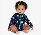 Child wearing Primary Baby One-Piece Rash Guard in Navy Ivory Pinwheels. Available from www.tenlittle.com