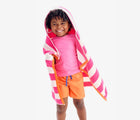 Child wearing Primary Hooded Towel in Bubblegum Stripe. Available from www.tenlittle.com