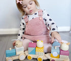 Girl playing with Bigjigs Wooden Stacking Train. Available from www.tenlittle.com.