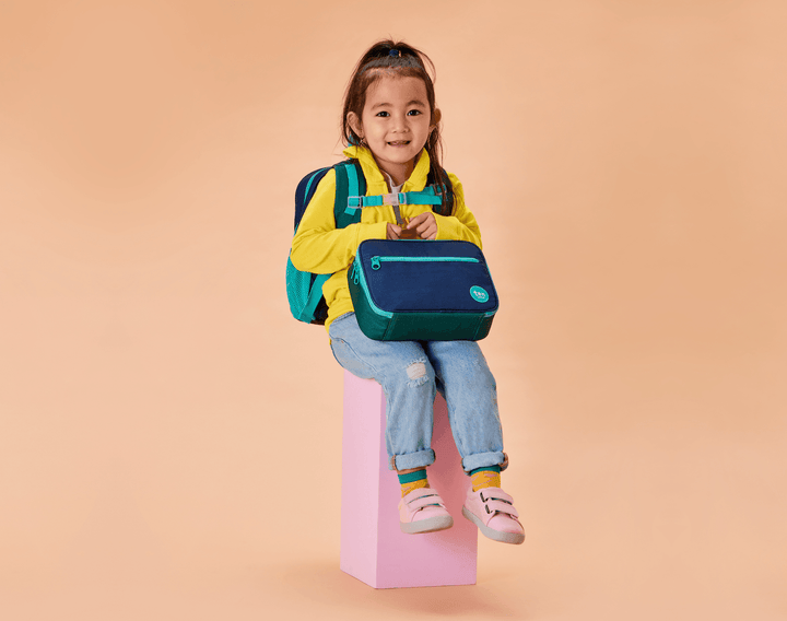 Girl carrying Ten Little Insulated Recycled Lunch Box - Navy & Green. Available at www.tenlittle.com