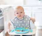 Baby in highchair wearing Bumkins Superbib in arrows. Available from tenlittle.com