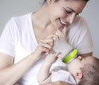 Woman feeding baby with Comotomo 8oz baby bottle. Available from www.tenlittle.com