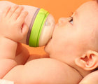 Baby drinking from Comotomo 8oz baby bottle. Available from www.tenlittle.com