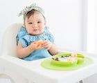 Baby Eating in high chair.  Ezpz Mini Mat in Lime. Available at www.tenlittle.com