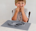 Child Eating using Ezpz Happy Mat in gray- Available at www.tenlittle.com