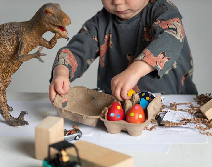Child playing with Eco-kids Dino Eggs Beeswax Crayons. Available from tenlittle.com