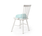 BabyBjörn Booster Seat in mint attached to a white chair. Available from tenlittle.com