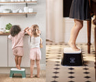 One view of two children in kitchen while one child is standing on BabyBjörn Step Stool in green, and another view of child standing on BabyBjörn Step Stool in black . Available from tenlittle.com