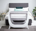 Béaba Convertible Air Bedside Sleeper Bassinet in a bedroom at the end of a bed. Available from tenlittle.com