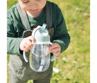 Child outside holding Beaba Straw Sippy Cup. Available from tenlittle.com