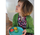 Child holding plate from Ekobo Bamboo Plate Set with food on it. Available from tenlittle.com
