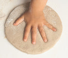 Child making hand print in sand casting medium for Eco-kids A Day at the Beach Kit