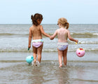 Girls holding Quut Mini Ballo Buckets on the beach