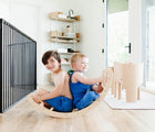 Two children playing on All Circles Balance Board & Rocker in a playroom. Available from tenlittle.com