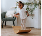Child standing on All Circles Wobble Board in a living room. Available from tenlittle.com