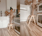 Two views of child in children using All Circles Two Step Stool in natural. Available from tenlittle.com