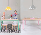 One view of two children playing using Nico & Yeye Craft Table in mint with Nico & Yeye stools next to it, and another view of Nico & Yeye Craft Table in pink, in a playroom underneath hanging light. Available from tenlittle.com