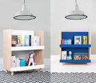 One view of Nico & Yeye Modern Kids Bookcase in white in a playroom underneath hanging light, and One view of Nico & Yeye Modern Kids Bookcase in pacific blue in a playroom underneath hanging light. Available from tenlittle.com