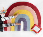Child laying on Nico & Yeye Rainbow Rug. Available from tenlittle.com