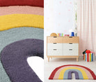 Close up view of Nico & Yeye Rainbow Rug, and view of Nico & Yeye Rainbow Rug in a playroom next to a dresser near a window. Available from tenlittle.com
