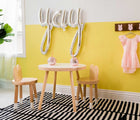 Nico & Yeye Round Craft Table in white with two cups on it, in a playroom next to a window, and two Nico & Yeye Bunny Chairs next to the table. Available from tenlittle.com