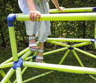 Child climbing on Eezy Peezy Monkey Bars Climbing Tower outside in a yard and wearing Ten Little Summer Sandals. Available from tenlittle.com