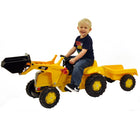 Boy riding Kettler CAT Tractor with trailer